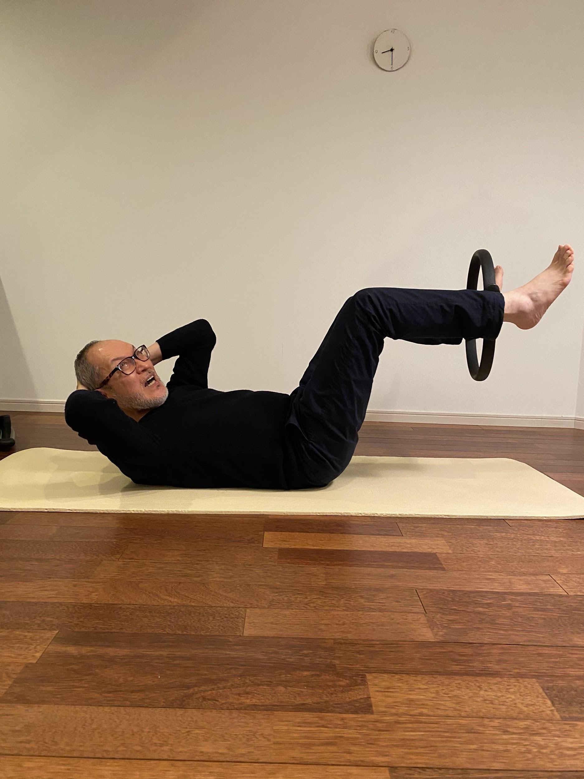 写真) ピラティスリングを使った腹筋運動
