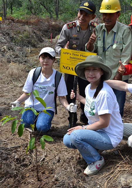 写真1:植樹イベントでフタバガキの苗木を植えたボランティアの母娘