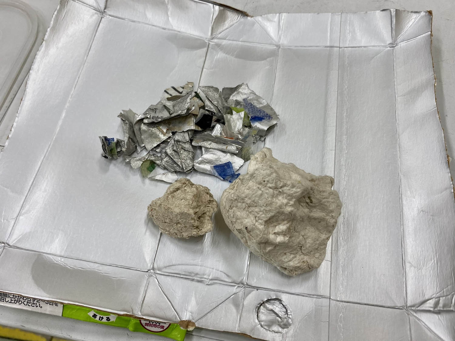 写真)パルパー型分離機で分離回収されたプラスチック付アルミ(上)と紙パルプ(下)。