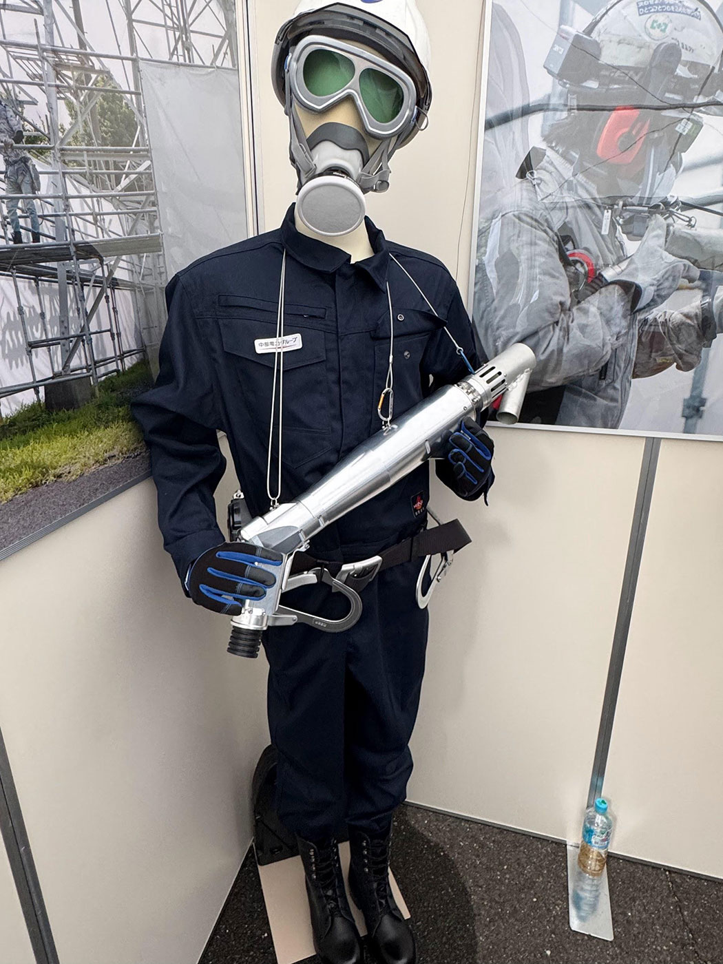 写真)保護具類を身につけレーザーヘッドを手に持つレーザー照射処理施工士のマネキン