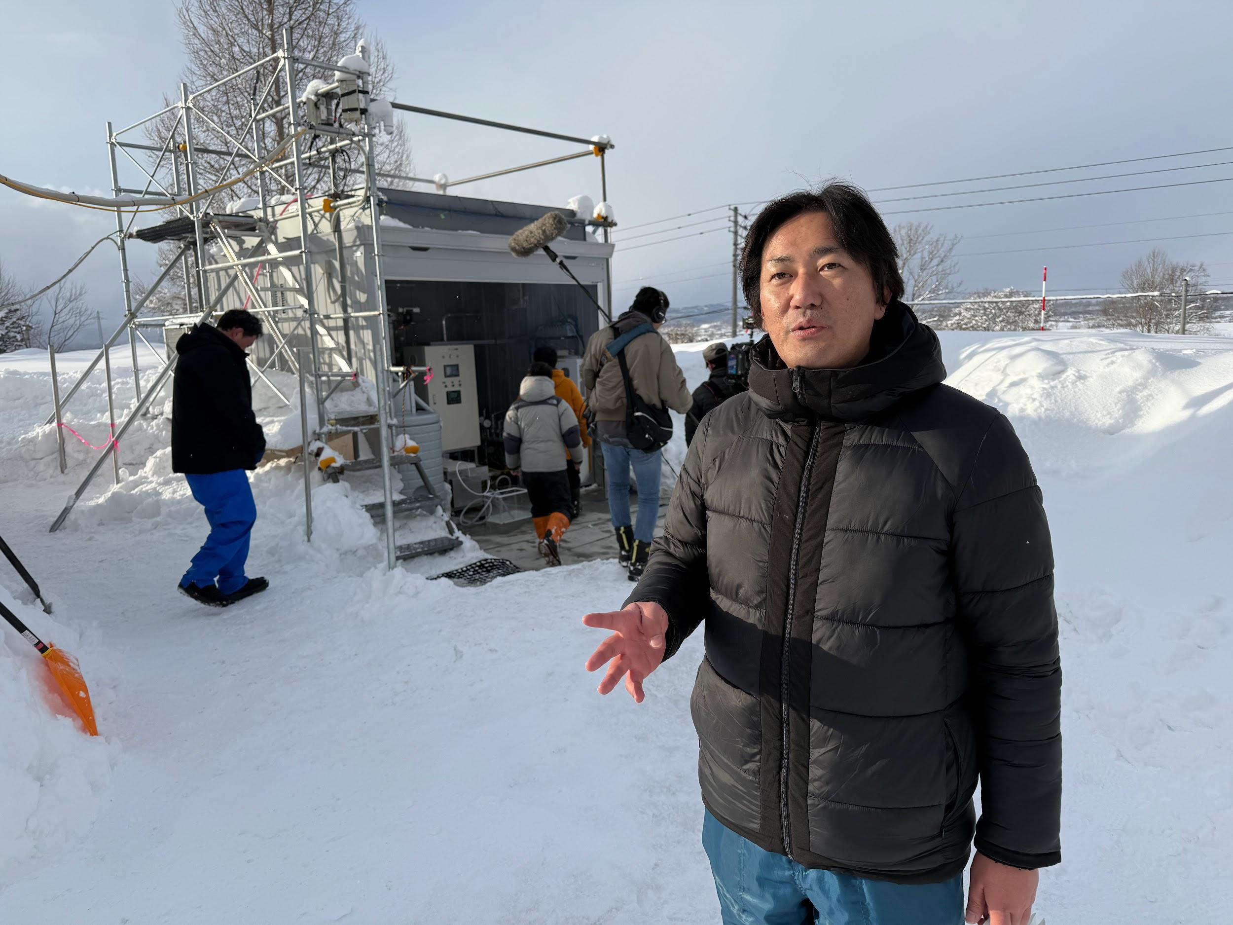 写真)施設の前で説明する榎木光治准教授